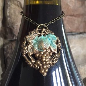 Wine bottle charm also worn as necklace.